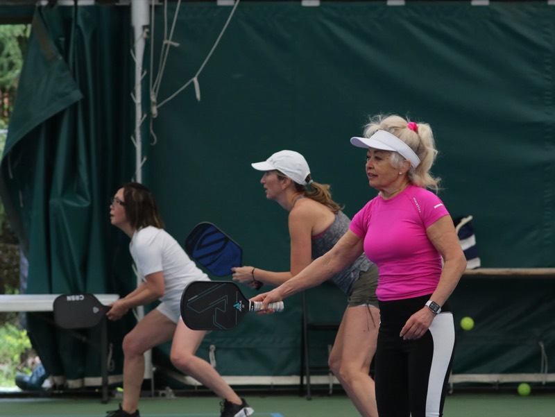 Players in a pickleball rally on the indoor courts